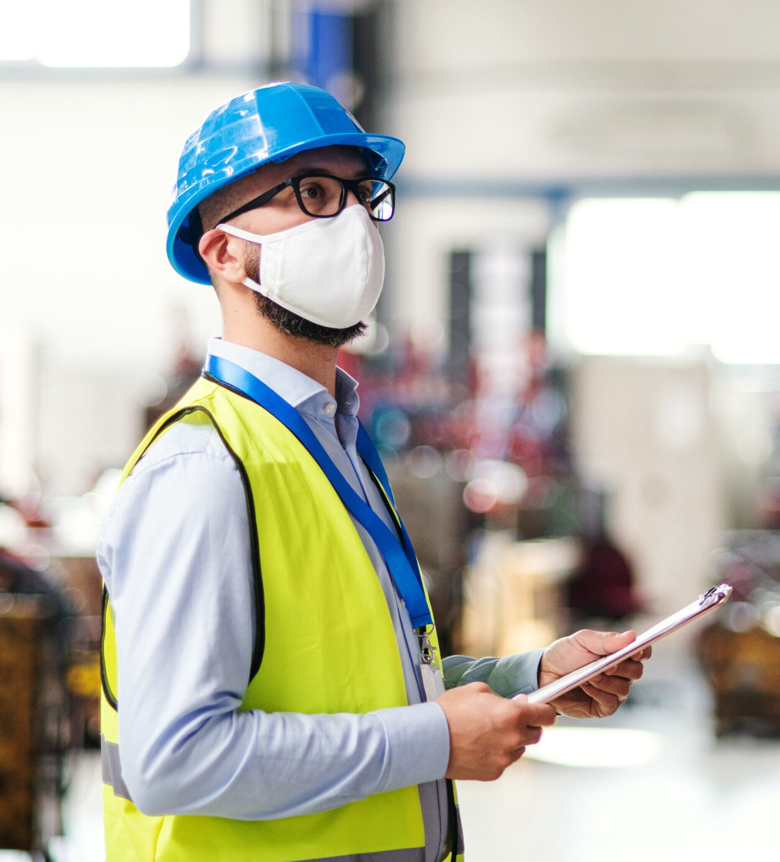 technician or engineer with protective mask and helmet working in industrial factory.